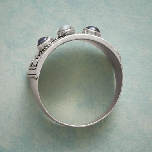 Eleganter geometrischer Ring mit kunstvoll geschnitzter Perle und funkelnden drei Steinen