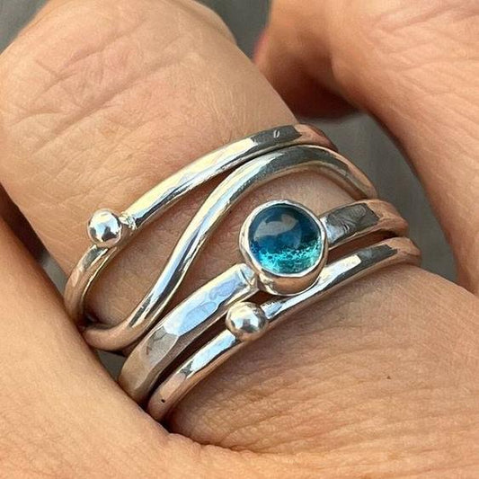 Eleganter geschichteter Ring mit strahlend blauem Kristall